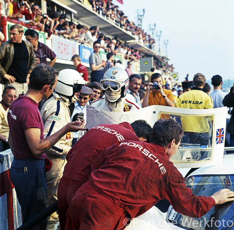 Richard Attwood (white helmet) and Vic Elford (silver helmet) discuss their progress in the 1969 Le Mans 24 Hour
