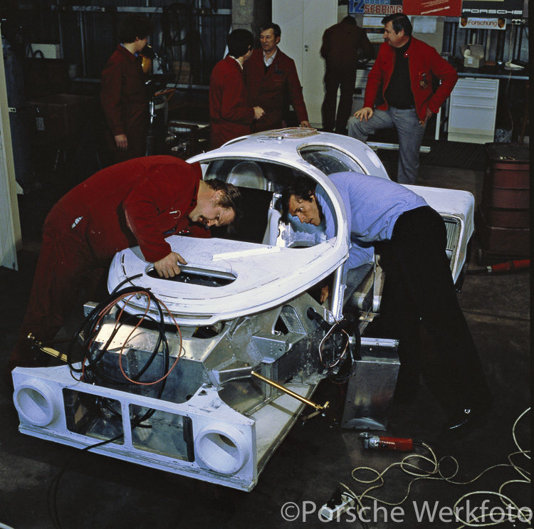 A group of Porsche technicians work on assembling an early Porsche 956 at Weissach in 1982