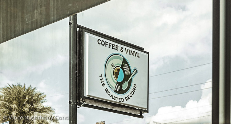 View of the coffee shop signage taken through the front window of the new home of The Roasted Record, in Stuart, Florida