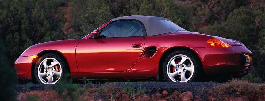 Red metallic Porsche Boxster 986 with gray soft top