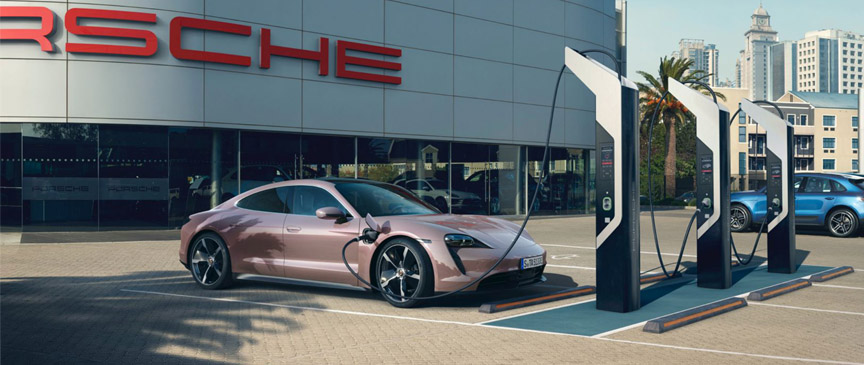 Porsche Taycan charging in front of the Porsche center