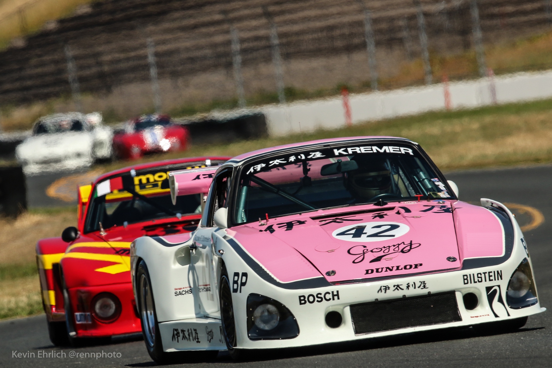 Porsche 935/78 on race track ahead of red and yellow car