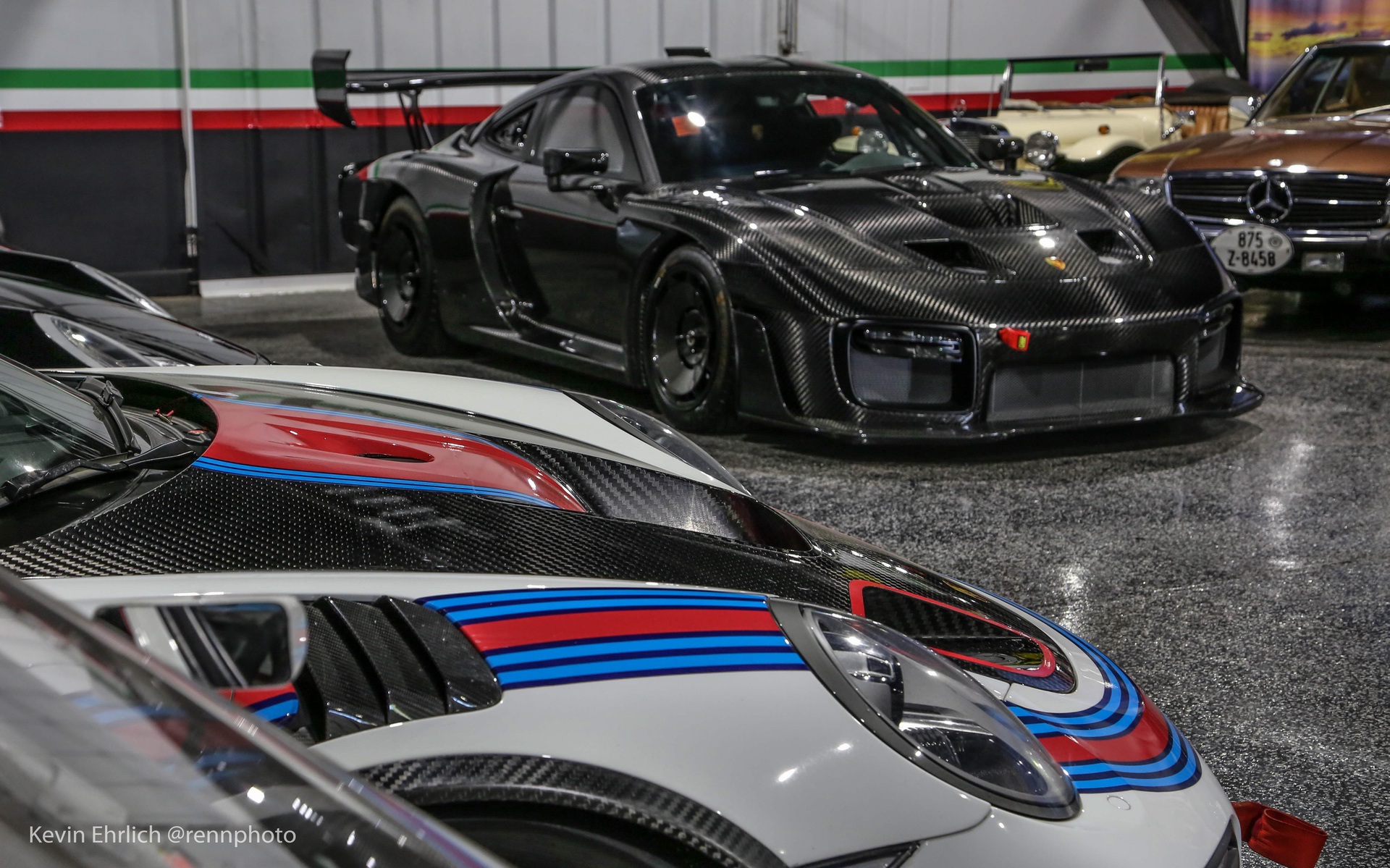 Black carbon fiber Porsche 935/19 in showroom with other cars