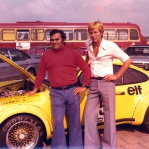 Photo from 1976 of two men standing in front of yellow Porsche 934 in the Netherlands