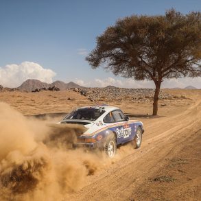 Amy Lerner's 1982 Porsche 911 SC racing through desert during 2022 Dakar Classic