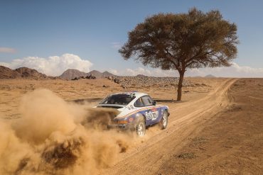 Amy Lerner's 1982 Porsche 911 SC racing through desert during 2022 Dakar Classic