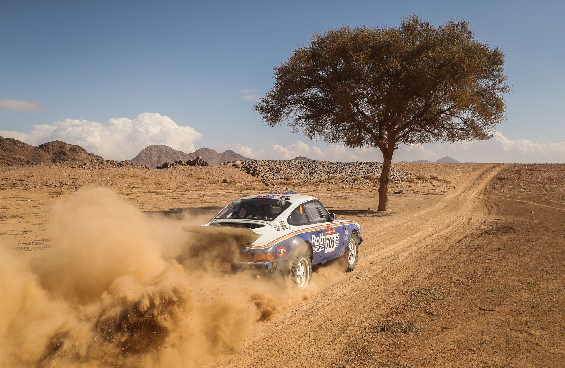 Amy Lerner's 1982 Porsche 911 SC racing through desert during 2022 Dakar Classic