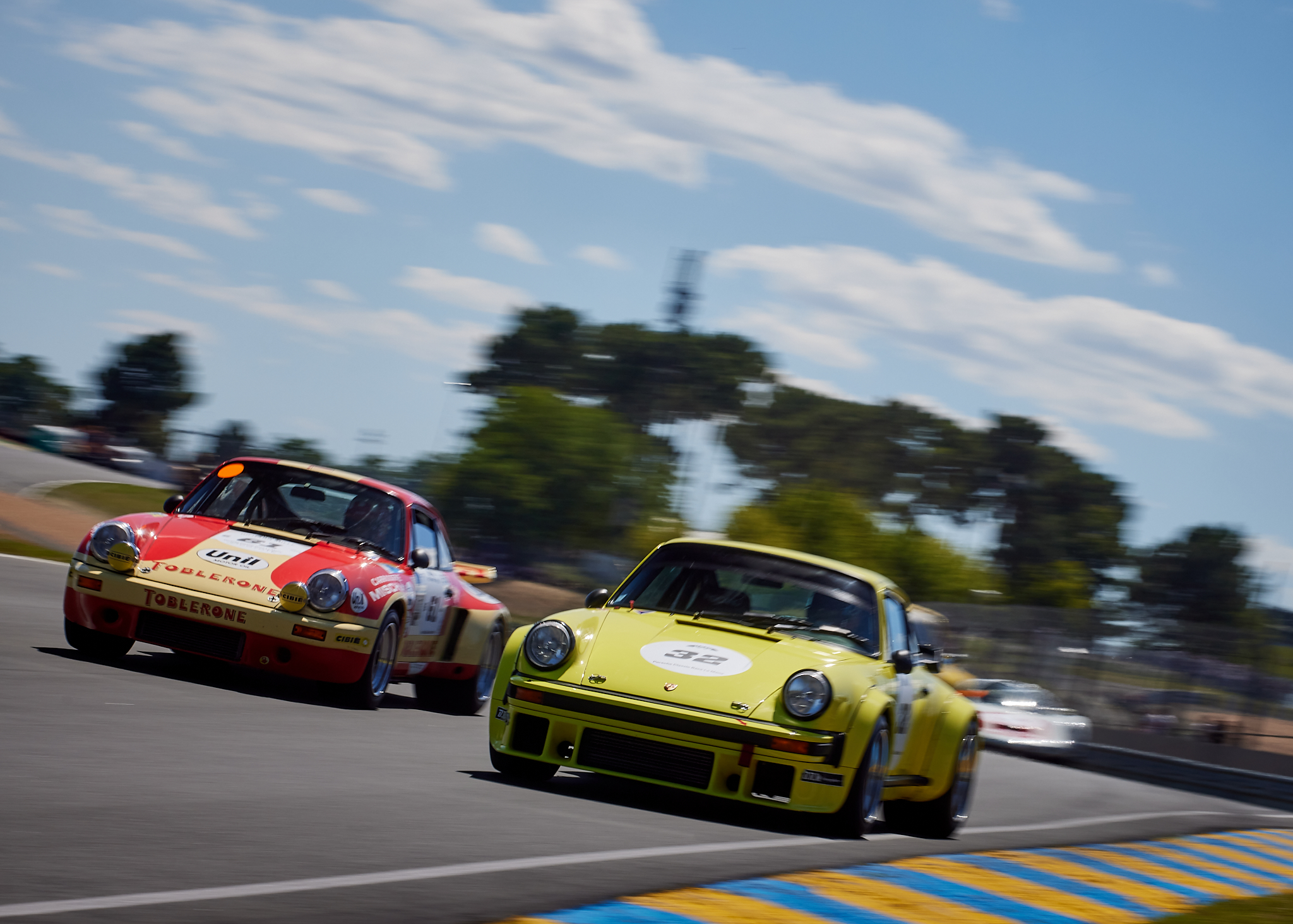 Porsches joust for position on the run down to Tertre Rouge, in the Porsche Classic Race.