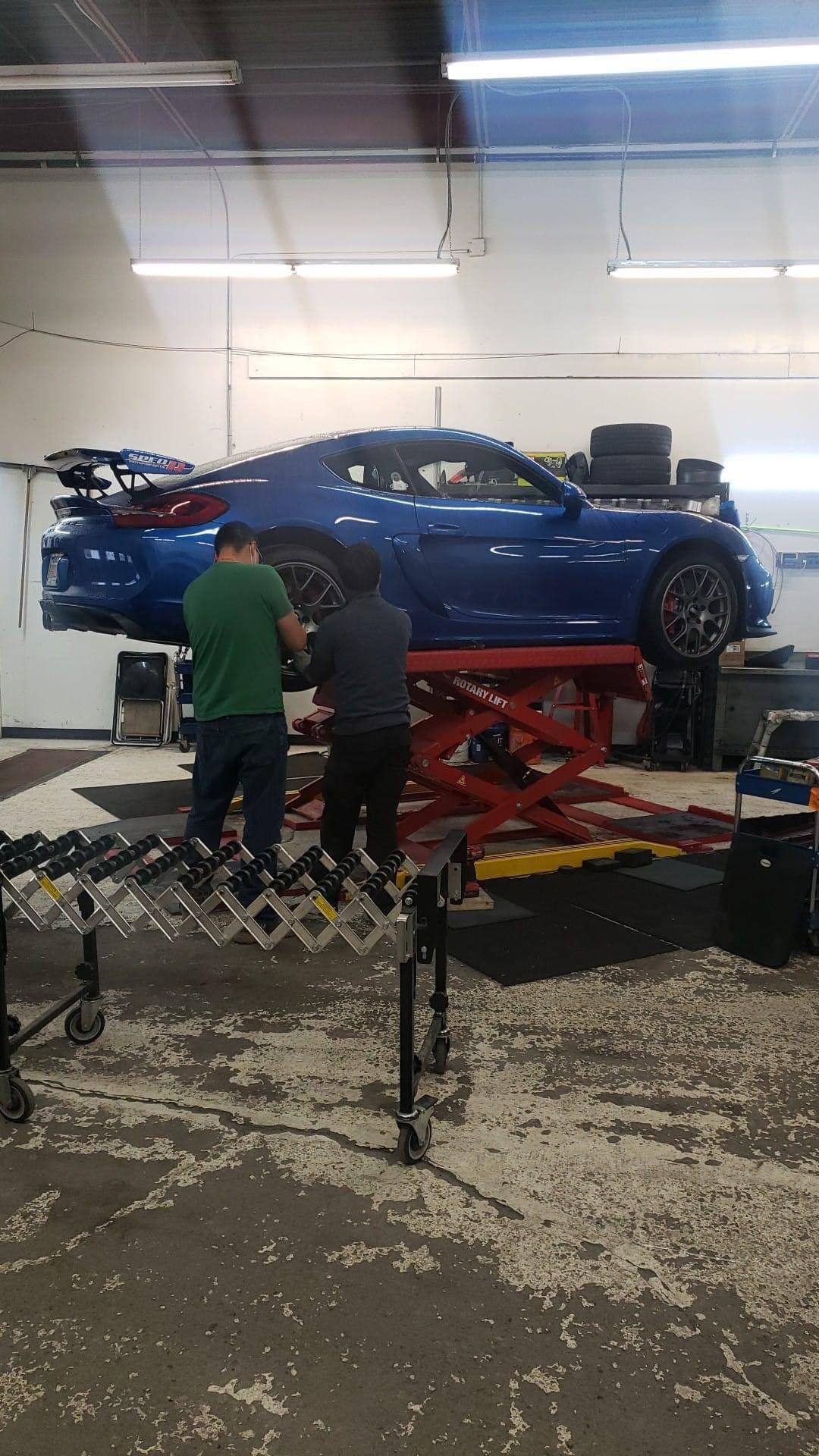 Mechanic inspecting performance car before driving event