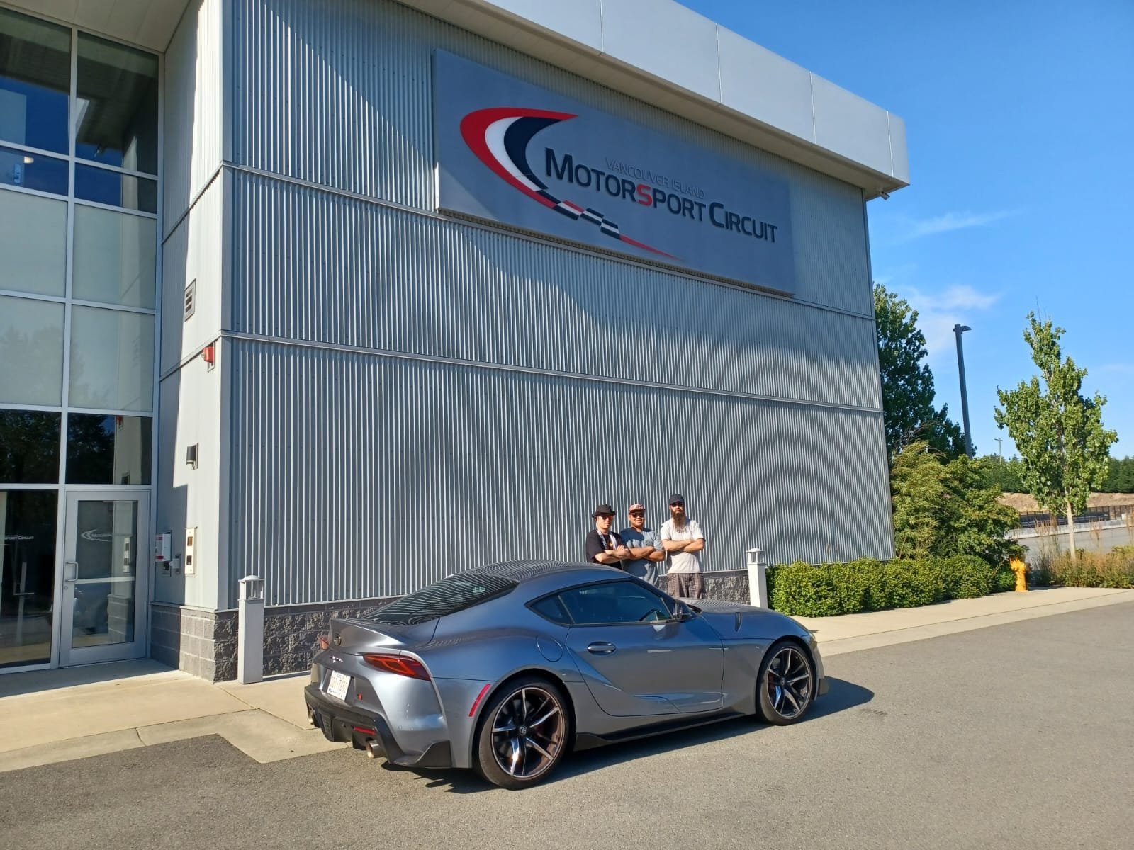 Group of drivers outside Motorsport Circuit building after high performance driving event