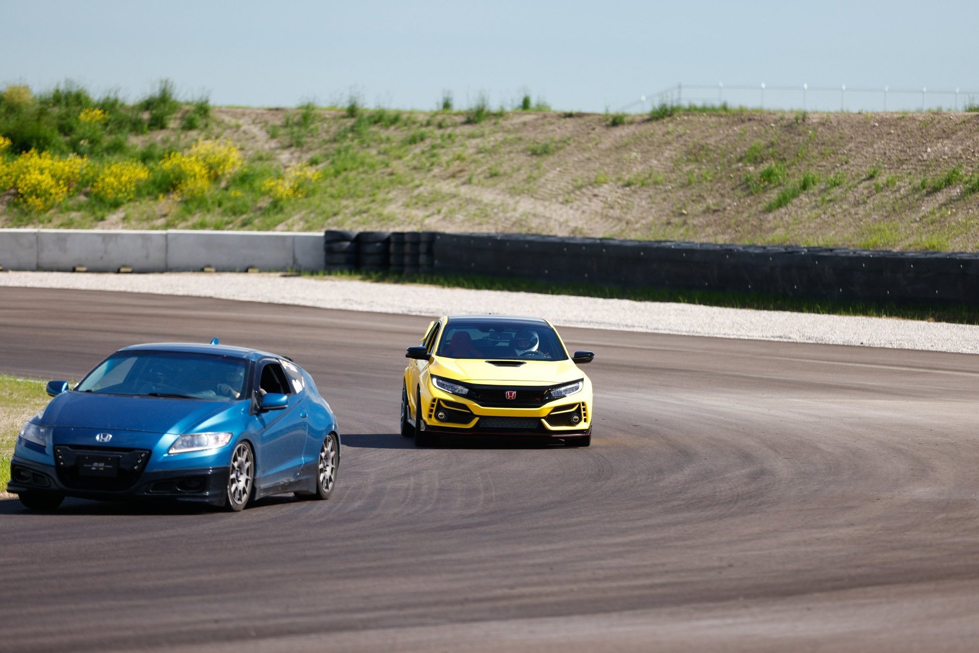Two Hondas racing around a track