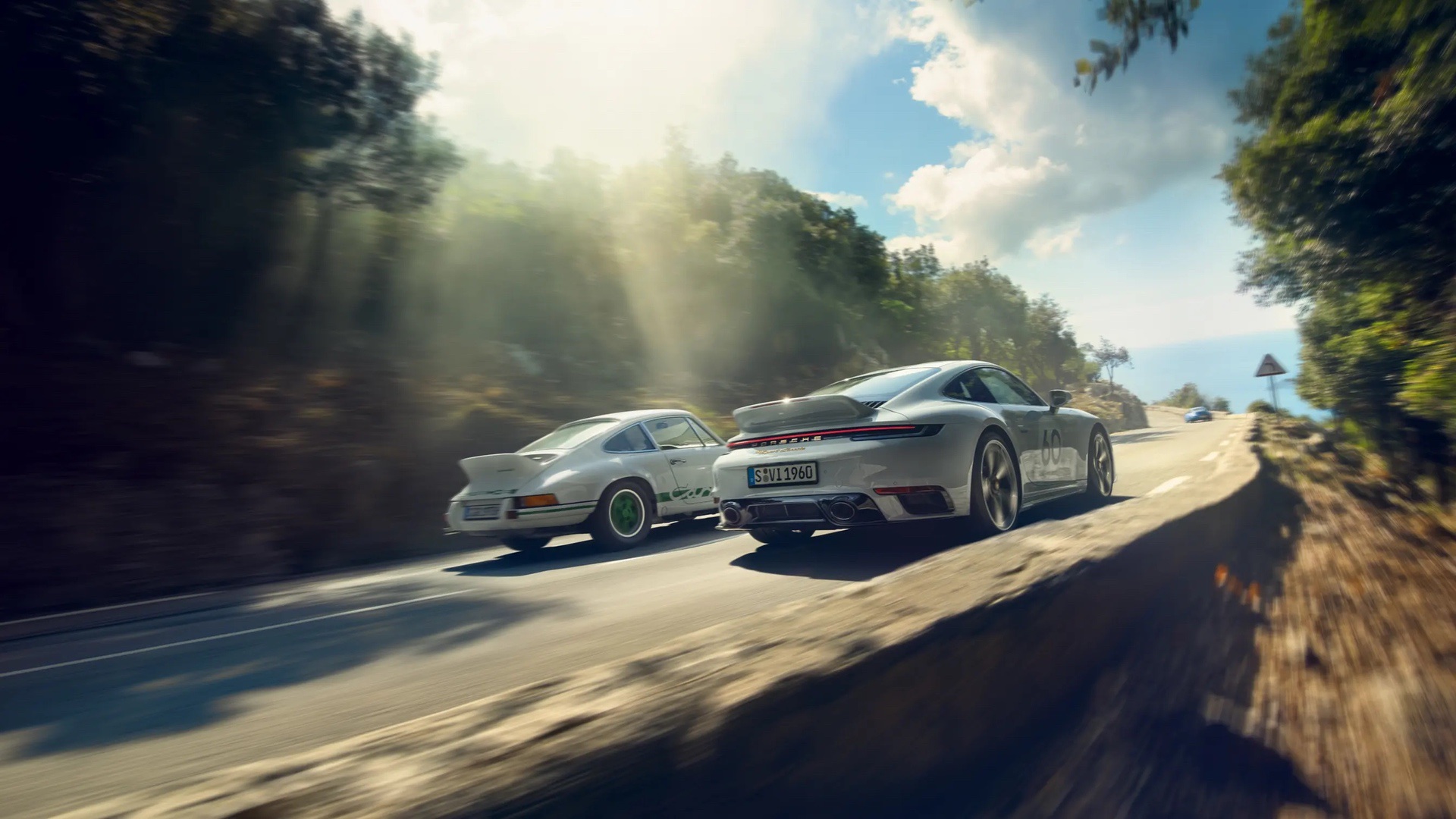 The 2023 Porsche 911 Sport Classic driving beside one of the cars that inspired it, the Carrera 2.7 RS