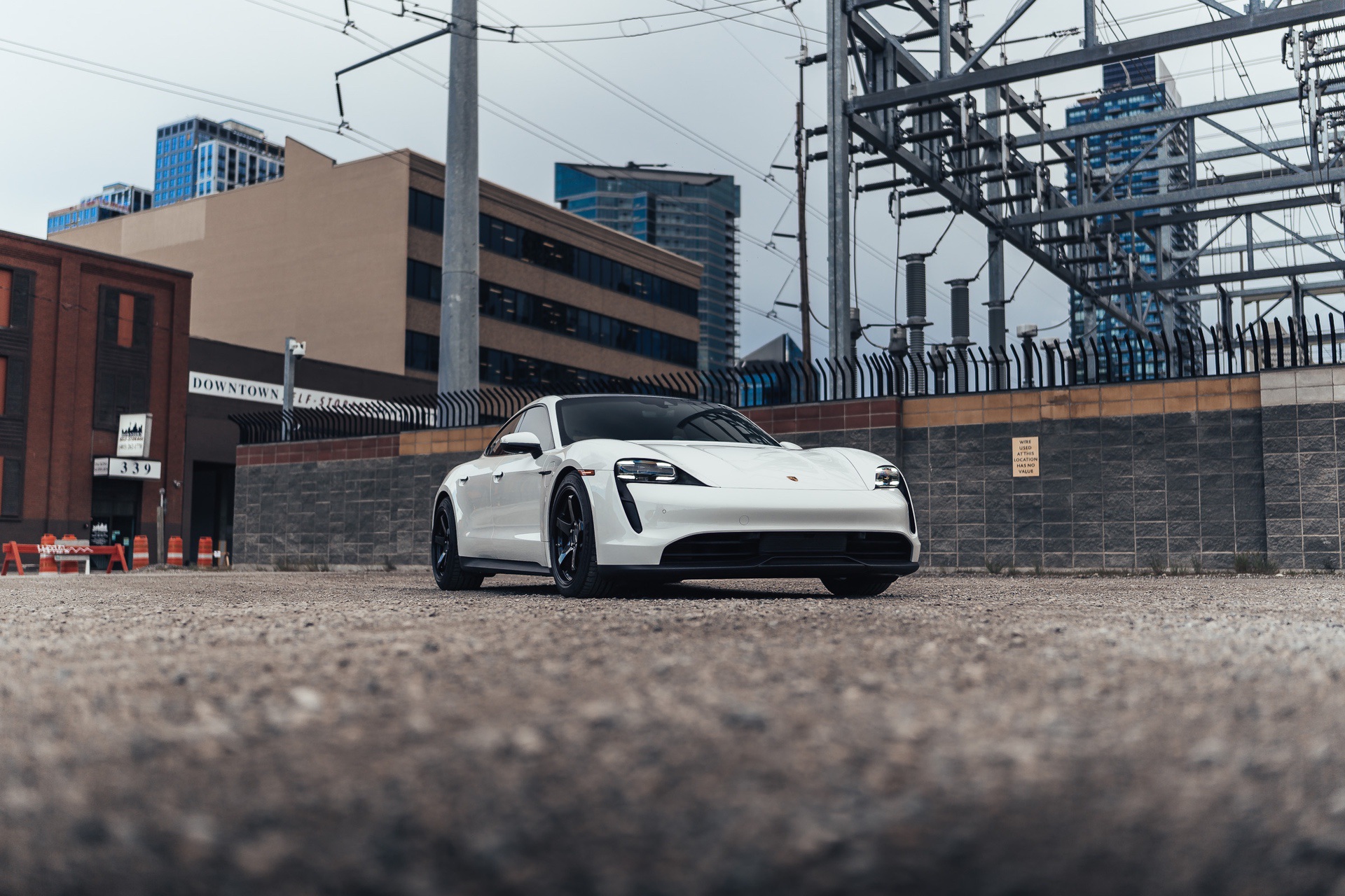 White Porsche Taycan electric car in industrial area