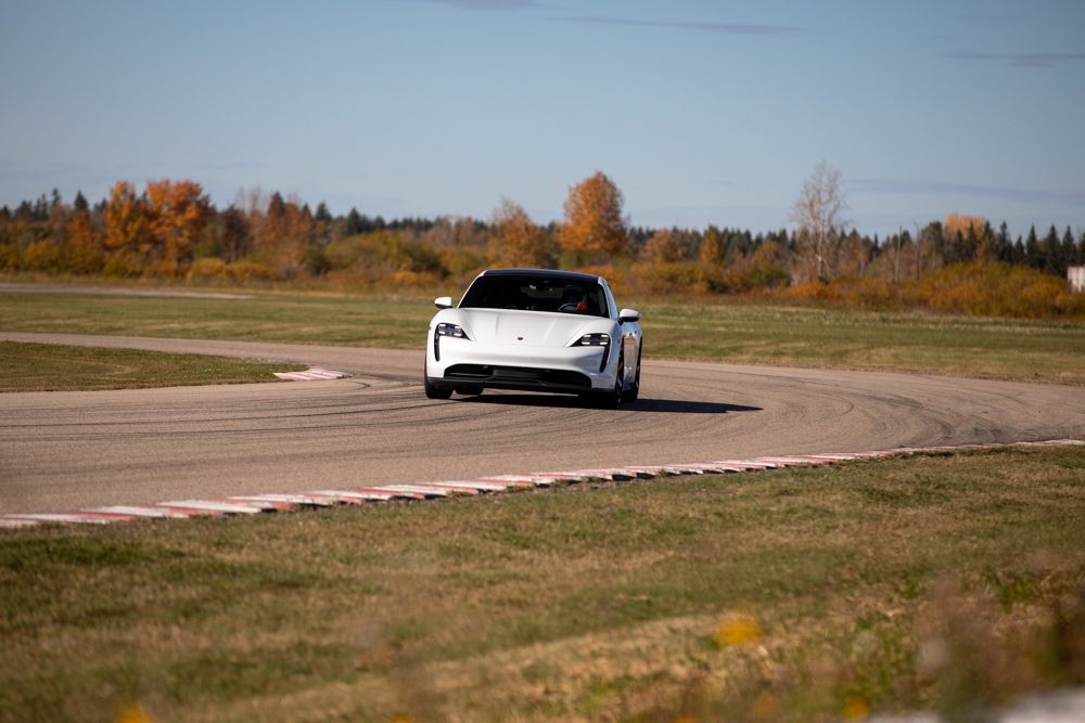 Porsche EV driving around curve on racetrack