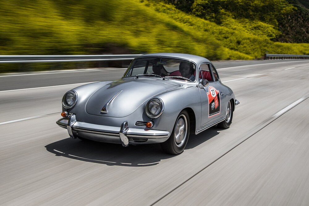 Side-angled shot of a gray Porsche 356C rolling along the highway.