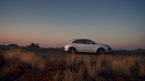 side view of a 2024 white Porsche Cayenne Turbo E-Hybrid Coupe