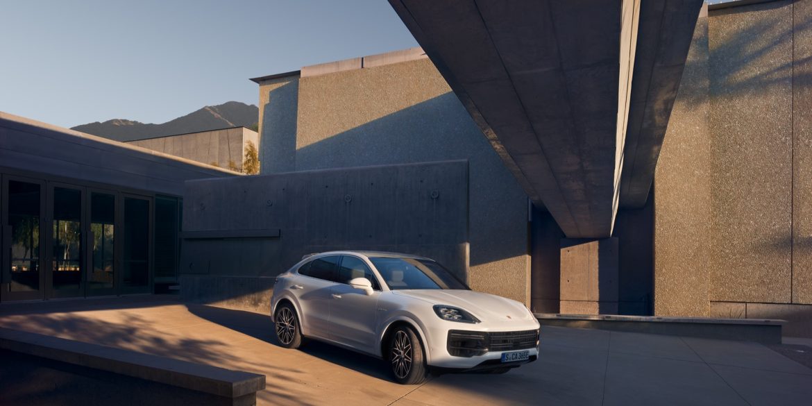 Three-quarter side view of a 2024 white Porsche Cayenne Turbo E-Hybrid Coupe