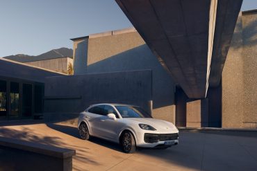 Three-quarter side view of a 2024 white Porsche Cayenne Turbo E-Hybrid Coupe
