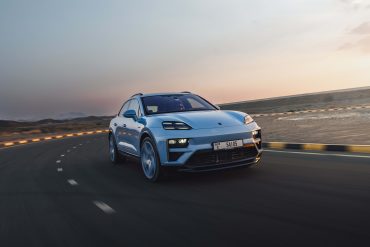 Three-quarter side view of a 2024 blue Porsche Macan Turbo Electric