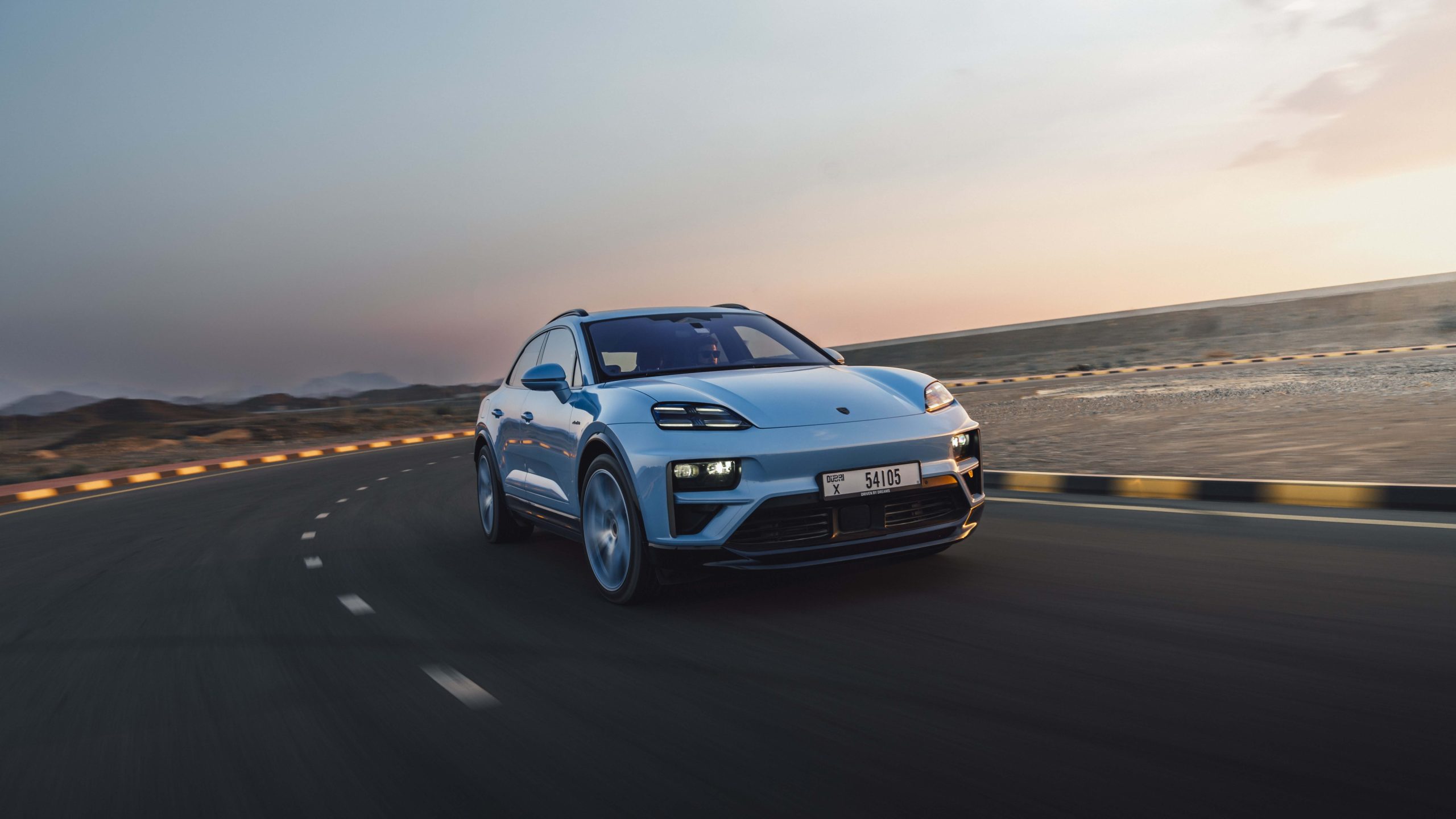 Three-quarter side view of a 2024 blue Porsche Macan Turbo Electric