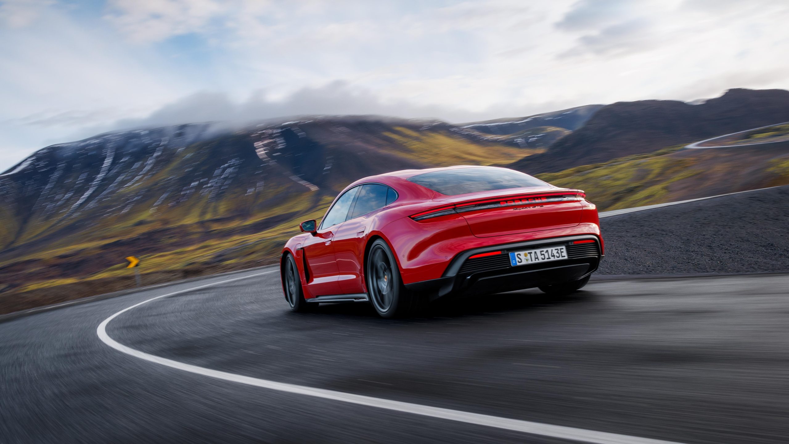 Three-quarter rear view of a 2025 red Porsche Taycan GTS