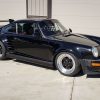 Three-quarter view of a 1987 modified black Porsche 930 Turbo