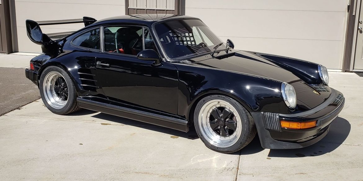 Three-quarter view of a 1987 modified black Porsche 930 Turbo