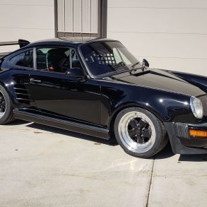 Three-quarter view of a 1987 modified black Porsche 930 Turbo