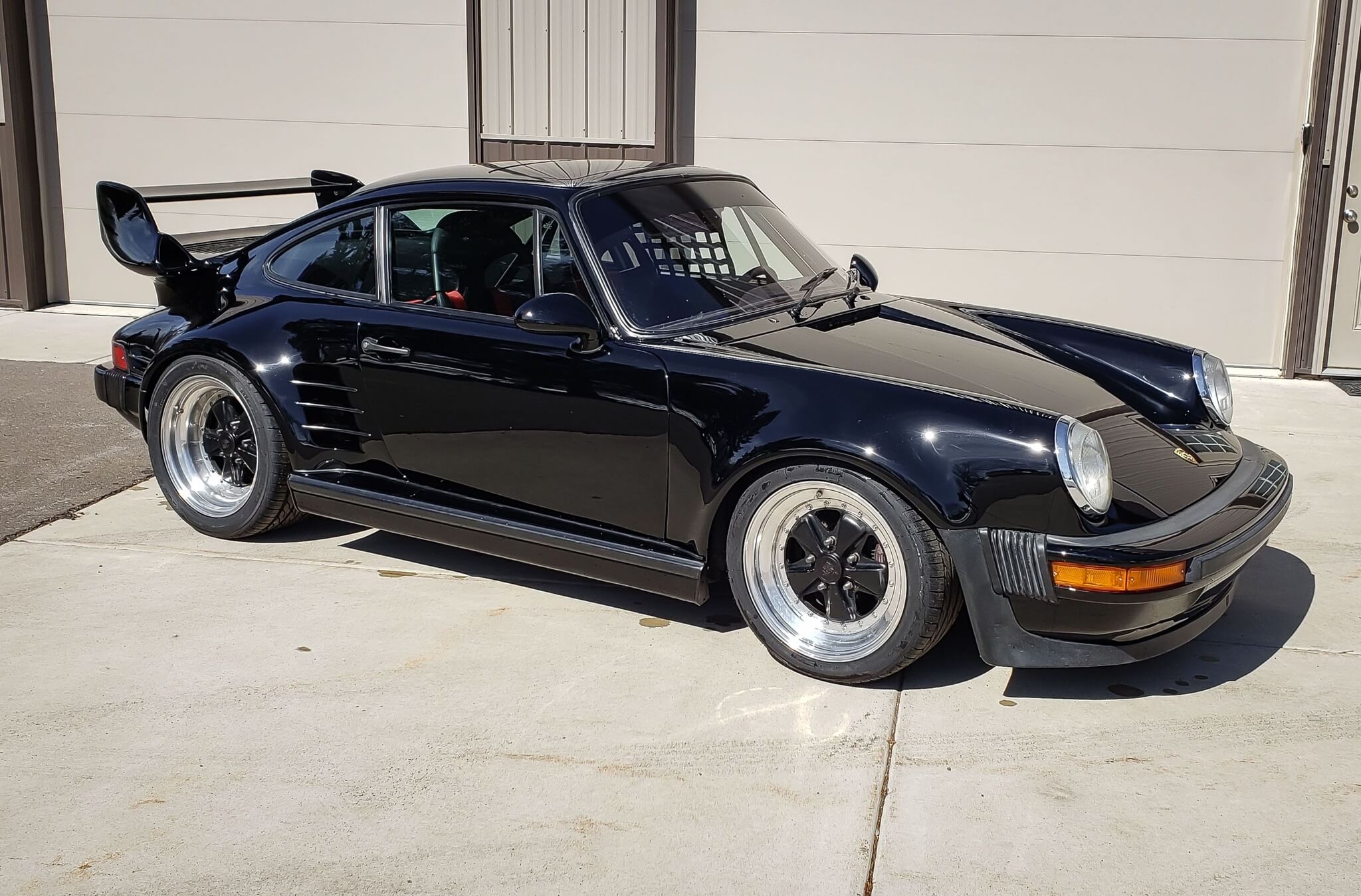 Three-quarter view of a 1987 modified black Porsche 930 Turbo