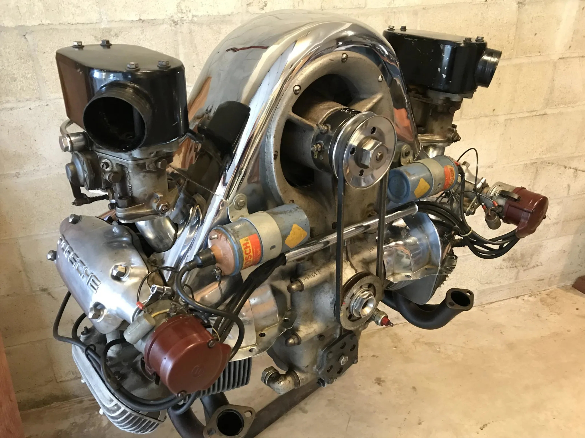 The Porsche 550 was powered by the Type 547 “Fuhrmann” engine — a 1.5-liter, air-cooled flat-four engineered with dual overhead camshafts and roller-bearing crankshaft construction. On paper, its output was impressive for displacement; in practice, its durability was the true differentiator. At events like the 24 Hours of Le Mans, the 547 sustained high RPM for extended periods along the Mulsanne without sacrificing mechanical integrity. That ability to combine advanced valvetrain architecture with endurance reliability allowed Porsche to compete — and win its class — against significantly larger engines.