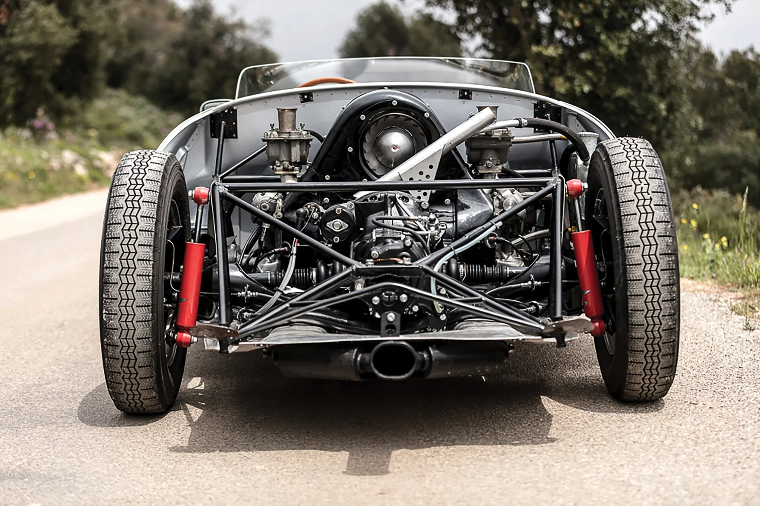 In the Porsche 550, the engine’s placement ahead of the rear axle was the defining structural decision. By centralizing mass and reducing polar moment, the chassis rotated more progressively and recovered more predictably at the limit. Combined with the car’s low overall weight, that balance reduced strain on tires and brakes while giving drivers greater control under load — especially over long distances where consistency mattered more than theatrics.