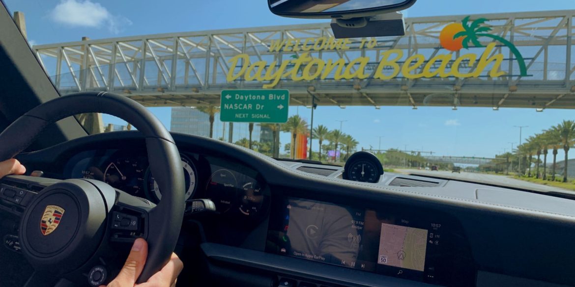 Porsche driver passing under the Welcome to Daytona Beach sign in Florida.
