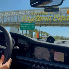 Porsche driver passing under the Welcome to Daytona Beach sign in Florida.