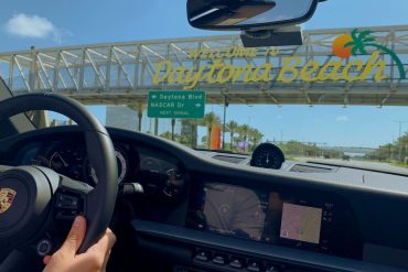 Porsche driver passing under the Welcome to Daytona Beach sign in Florida.