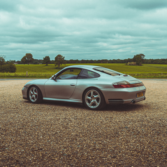 3/4 rear view of a silver 911 996 Porsche in the UK's countryside