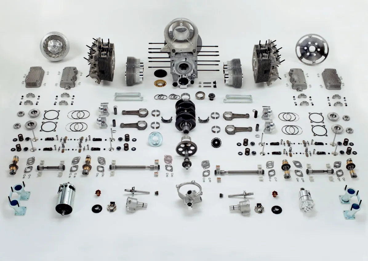Disassembled, the Ernst Fuhrmann–designed Type 547 revealed just how complex Porsche’s 1.5-liter four truly was. Four overhead camshafts, driven by vertical shafts and bevel gears, eliminated timing instability at high engine speeds, while a roller-bearing crankshaft reduced friction and controlled heat under sustained load. Dual spark plugs per cylinder improved combustion efficiency and stability, particularly critical as revs climbed beyond 7,000 RPM in later competition form. Dry-sump lubrication ensured constant oil supply during prolonged high-speed cornering and extended flat-out operation. The result was not simply a high-revving engine, but one engineered to survive at those speeds for hours — a defining requirement in endurance racing.