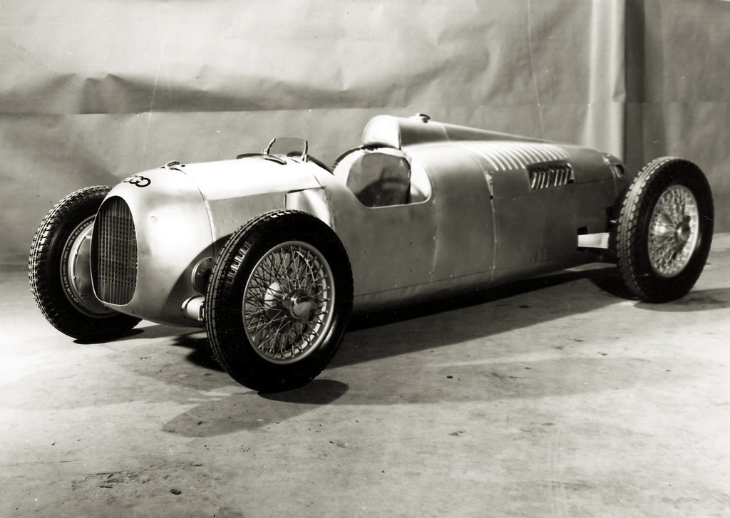 The 1935 Auto Union Type B refined the radical formula introduced by the Type A, combining a larger V16 engine with continued development of the chassis, suspension, brakes, and bodywork. Its centrally located fuel tank was intended to limit changes in balance during a race, but the car still demanded enormous concentration as tire wear, fuel consumption, and suspension movement altered its behavior. More powerful and more developed than its predecessor, the Type B pushed Porsche’s rear-engined Grand Prix concept another step toward the terrifying performance of the Type C.
