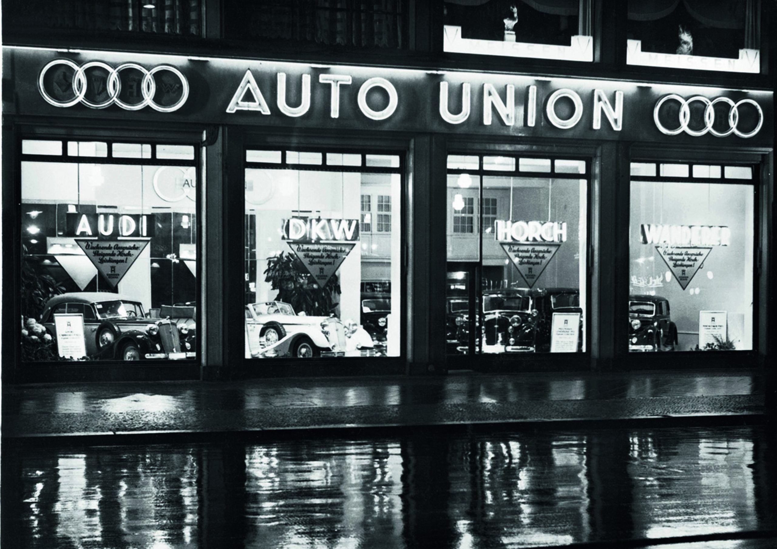 The formation of Auto Union brought Audi, DKW, Horch, and Wanderer together under one corporate structure at a moment when Germany’s automobile industry was fighting to survive. The merger created a company with the scale, resources, and product breadth to challenge Daimler-Benz, while the four interlocking rings gave the new organization a clear visual identity. Just as importantly, Auto Union would provide the backing needed to transform Porsche’s experimental P-Wagen into a full Grand Prix racing program.