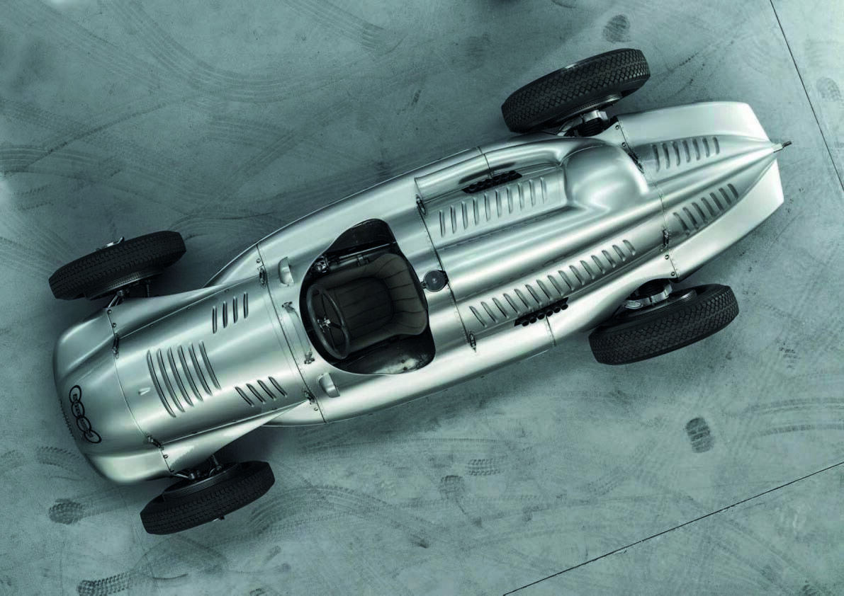Viewed from above, the Type D’s tightly packaged form becomes especially clear. The driver sat well forward, while the engine, cooling passages, exhaust outlets, and rear suspension were concentrated behind the cockpit beneath carefully shaped bodywork. The result was a compact, purposeful machine whose layout anticipated the basic architecture that would eventually define modern Grand Prix racing.