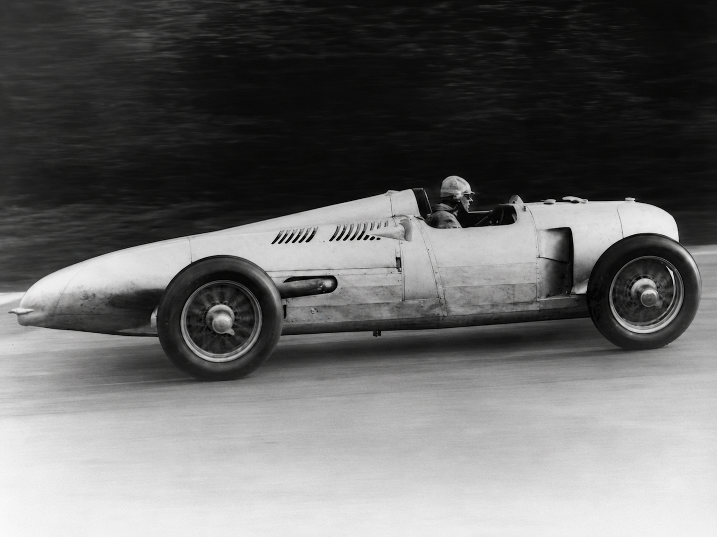 The P-Wagen’s mid-engine layout placed the driver low and far forward in the chassis, with little structure between the cockpit and the front of the car. That position improved aerodynamics and lowered the center of gravity, but it also left the driver dangerously exposed in a frontal impact. Combined with an open cockpit, limited restraints, and the car’s notoriously demanding handling, even a small mistake could have catastrophic consequences.