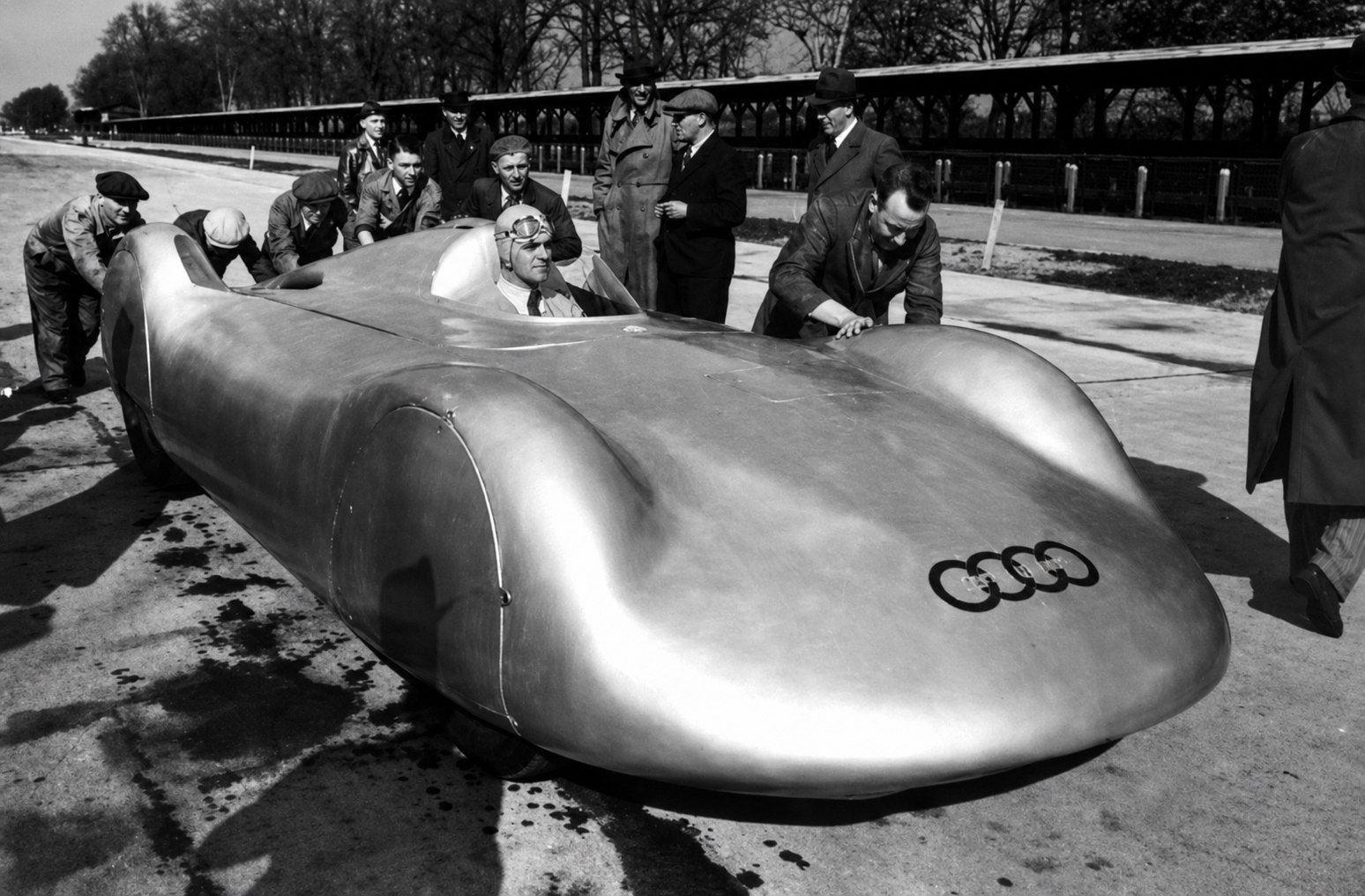 Bernd Rosemeyer is shown at the Frankfurt–Darmstadt autobahn on January 28, 1938, preparing to drive Auto Union’s streamlined record car in pursuit of a new high-speed mark. The attempt was part of the fierce rivalry between Auto Union and Mercedes-Benz, with both teams using the autobahn to demonstrate the limits of German engineering, aerodynamics, and power. For Rosemeyer, it was another chance to push beyond what had previously seemed possible—under conditions that offered almost no margin for error.