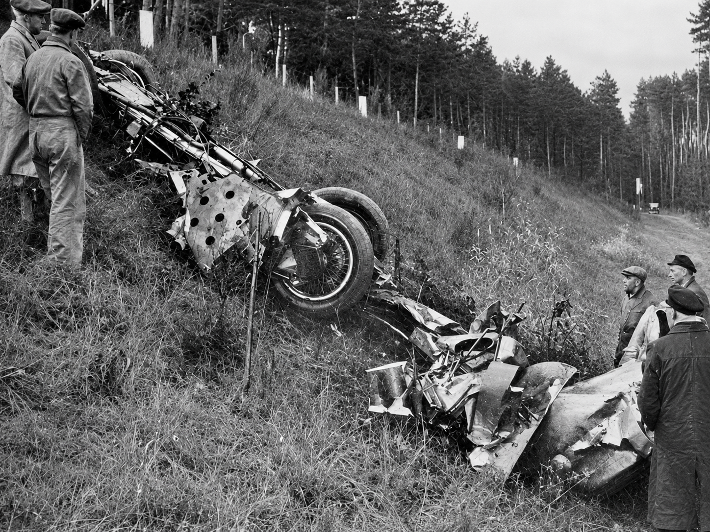 The wreckage of Rosemeyer’s Auto Union streamliner reveals the violence of the January 28, 1938 crash. Although the precise sequence remains uncertain, the most widely accepted explanation is that a strong crosswind—or a sudden aerodynamic instability intensified by that wind—caused the car to lose control at more than 400 km/h. Once it left the autobahn, the streamliner became airborne and disintegrated, throwing Rosemeyer from the cockpit and killing him at the age of twenty-eight.