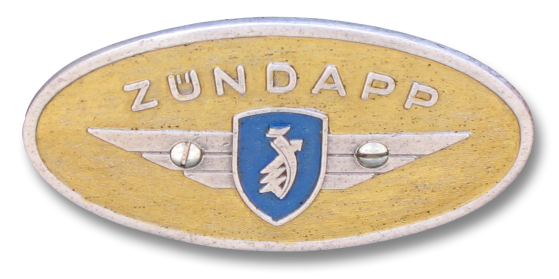 The Zündapp logo represents the company that, in 1931, commissioned Ferdinand Porsche to design a compact car as it sought to enter the automobile market. This collaboration resulted in the Porsche Type 12, an early prototype that explored a rear-engine layout and air cooling—key concepts that would evolve in later designs. While the Type 12 never reached production due to Zündapp’s shift back to motorcycles, it marked a critical step in Porsche’s pursuit of an affordable, practical people’s car.
