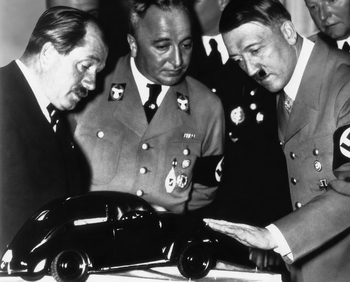 By the mid-1930s, Ferdinand Porsche understood that survival and expansion within Germany’s new political order required access to the Nazi state and the patronage that came with it. The Volkswagen project offered his engineering office unprecedented resources and national importance, but accepting that opportunity also meant working directly within a regime that was already excluding, persecuting, and dispossessing men such as Adolf Rosenberger. Porsche was not merely a passive victim of circumstance: he pursued influence, contracts, and institutional power within the system, even as the system increasingly rewarded political conformity and personal proximity to Hitler. The result was a relationship defined by both dependence and ambition, in which professional survival became inseparable from moral compromise.