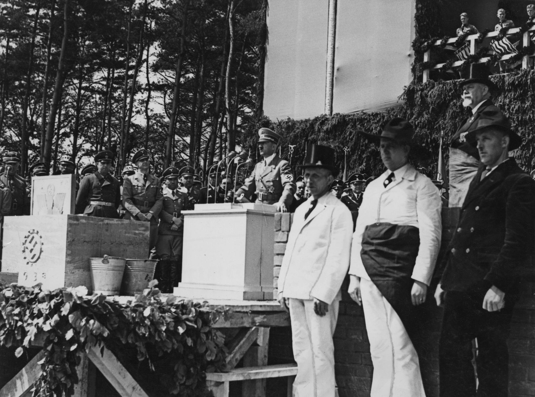 The 1938 foundation ceremony for the Volkswagen factory near Fallersleben marked the point at which Porsche’s Type 60 moved beyond prototype development and became the centerpiece of a vast state-directed industrial program. The event was staged with full political ceremony, presenting the new factory as proof that the Nazi regime could deliver modern manufacturing, employment, mobility, and consumer opportunity on a national scale. In reality, the project depended upon the resources and authority of the German Labour Front, while the KdF-Wagen itself was increasingly used as a symbol of loyalty, progress, and inclusion within the regime’s racial community. The ceremony therefore represented both an important industrial milestone and a carefully managed propaganda event. It was the moment when Porsche’s automobile became inseparable from the political system financing, promoting, and ultimately controlling its future.