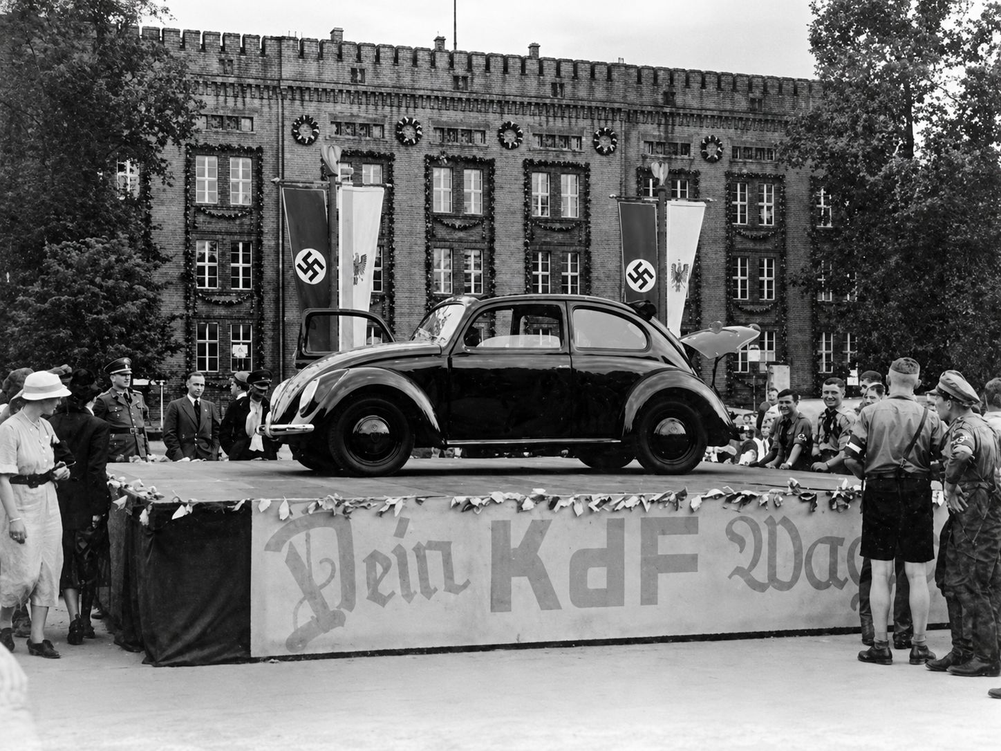 Hundreds of thousands of Germans paid into the KdF savings program expecting to receive an affordable “people’s car,” but the promise was never fulfilled for nearly all of them. After war began in 1939, the Volkswagen factory and its resources were redirected toward military production, while savers were left without either the cars they had been promised or meaningful reimbursement.